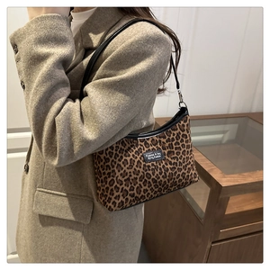 Dettaglio della borsa tote leopardata alla moda con bordo nero e toppa con logo