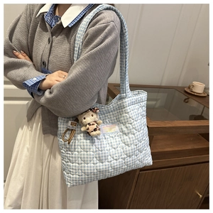 Detalle del bolso tote de cuadros azules y blancos con acolchado de corazones