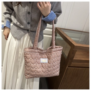 Detalle del patrón acolchado de corazones marrones y etiqueta en un bolso shopper