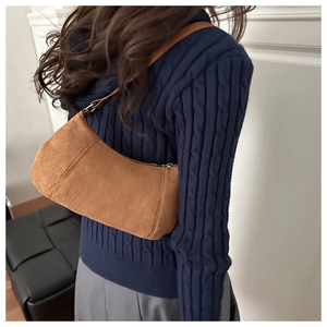 Détail d'un sac hobo en daim marron assorti à un pull en maille torsadée bleu marine