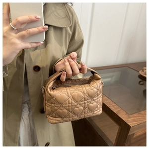 Close-up of khaki mini handbag with heart-shaped quilting and premium leather texture