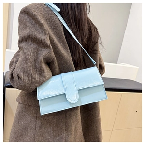 Detail showing light blue rectangle shoulder bag worn with a brown herringbone blazer