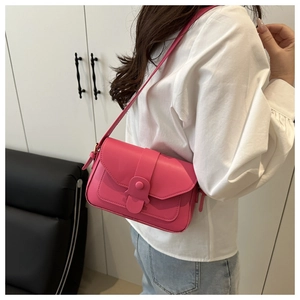 Détail du sac à bandoulière fuchsia avec bride à boucle sur un mannequin femme