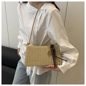 Detail of beige straw tote bag featuring herringbone weave and tennis racket charm