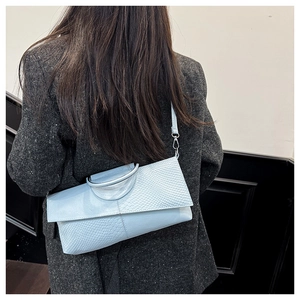 Light blue faux crocodile skin handbag showing textured surface and silver hook detail