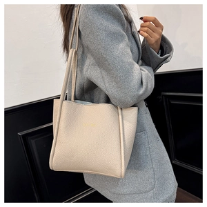 Creamy white lychee grain leather tote bag shown on model for a stylish urban look