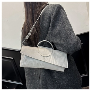 Detail of grey geometric clutch with snake pattern textures and detachable strap