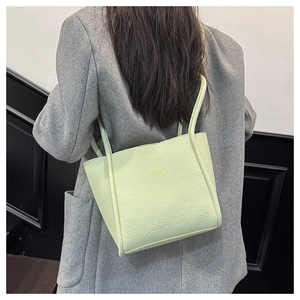Nahaufnahme einer hellgrünen Tragetasche aus Leder mit goldenem CUTE BAG Schriftzug