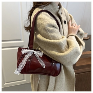 Sac baguette rouge foncé en cuir avec nœud en dentelle blanche et rivets argentés