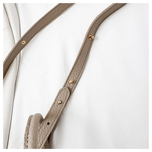 Detail of adjustable pebble leather shoulder strap with gold-tone hardware and buckle