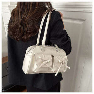 Back view of cream off-white patent leather shoulder bag with chic ribbon bows