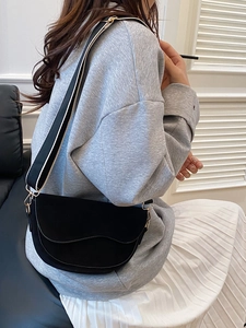 Classic black saddle bag in suede texture with a stylish black and white striped wide strap