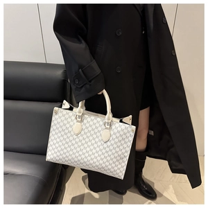Detail of vintage monogram tote bag with ivory M-pattern and sturdy handles for commuting