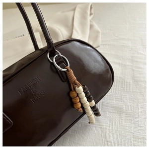 Macro detail of dark brown glossy leather bag with Fashion & Bags embossed logo