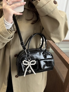 Glossy black high-capacity tote bag with pearl bow charm and adjustable shoulder strap