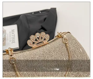 Detail of champagne gold evening bag showing crown rhinestone clasp and lace texture