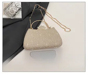 Macro shot of champagne gold evening bag showing crystal crown clasp and texture
