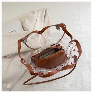 Dettaglio della borsa tote in PVC trasparente con stampa ciliegie e dettagli in ecopelle