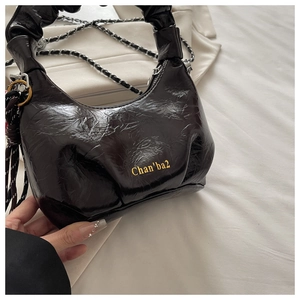 Detail of black pleated faux leather bag featuring silver chain and Chan'ba2 logo