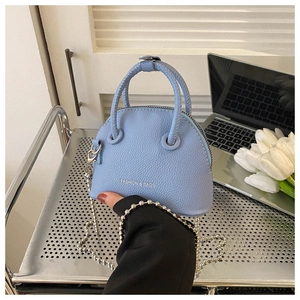 Detail of light blue shell bag with silver ball chain and fashion text printing