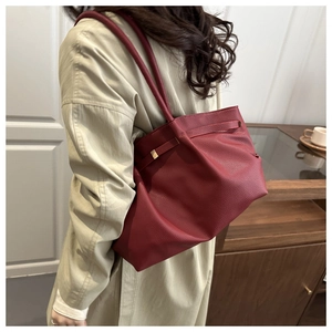 Détail du sac cabas bordeaux avec texture litchi et design plissé souple porté à l'épaule