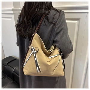 Détail du sac cabas kaki avec nœud rayé noir et blanc et détails de fermeture éclair