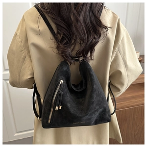 Gros plan du sac en daim noir avec fermeture éclair et texte tendance sur le mannequin