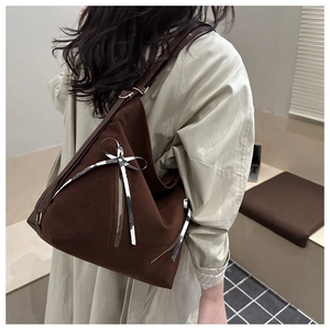 Détail d'un sac bandoulière marron en daim avec ruban zébré et accents de fermeture