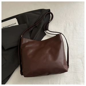 Vue détaillée du sac cabas en cuir marron foncé avec texture et détails dorés