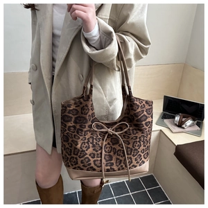 Detail of a large leopard print tote bag with bow accent and faux leather base