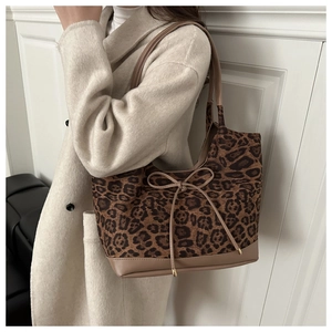 Close-up of leopard print tote bag with leather strap and decorative bow detail