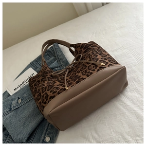 Close-up of leopard print tote bag with khaki leather trim and drawstring bow detail