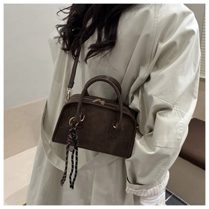 Dettaglio della borsa a bauletto vintage in camoscio marrone con foulard a righe