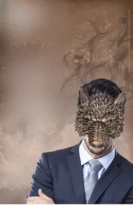 Detail view of a bronze wolf half-mask with realistic fur texture and sharp fangs