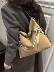 Sac cabas camel minimaliste avec détail nœud et sangle marron porté par un mannequin