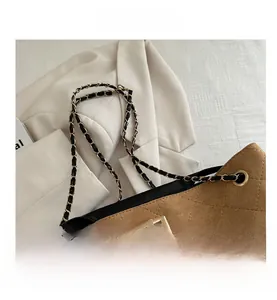 Detail of vintage brown suede chain bag with quilted diamond pattern and gold lock
