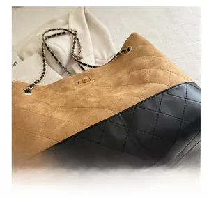 Detail of vintage quilted tote bag with brown suede and black faux leather contrast
