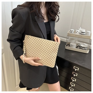 Detail of printed envelope clutch featuring polka dot pattern and detachable wrist strap