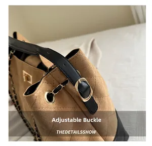 Detail of adjustable golden buckle and diamond quilted stitching on khaki suede bag