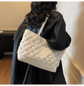 Detail of white plush pom-pom tote bag showing soft fluffy texture and leather base