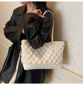 Detail of white plush tote bag with spherical texture and faux leather shoulder strap