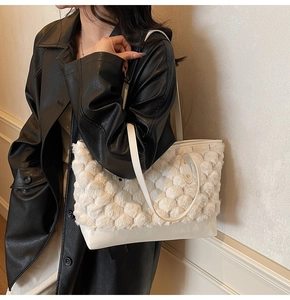 Detail of white plush textured tote bag with smooth leather bottom and slim shoulder strap