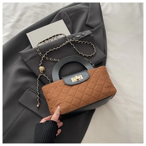 Detailed view of brown and black quilted crossbody bag with gold chain and twist lock