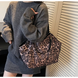 Detail of leopard print tote bag with golden twist lock and thick textured material