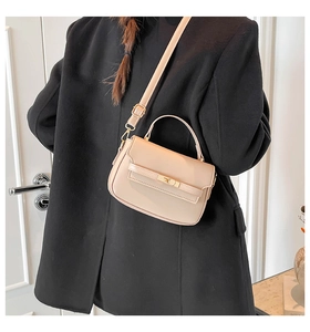 Vista posteriore di una borsa a mano beige con dettaglio cintura su un cappotto nero