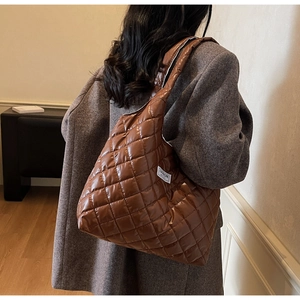Detailansicht der dunkelbraunen Stepptasche mit weißem Fashion-Etikett-Anhänger