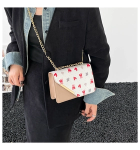 Dettaglio della borsa a tracolla beige con stampe di orsetti e cuori sulla patta bianca