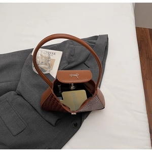 Detailed interior of brown crocodile pattern handbag showing space for lipstick and perfume