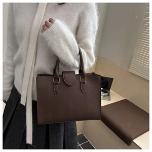 Borsa tote marrone a grana litchi abbinata a un maglione di mohair bianco per ufficio
