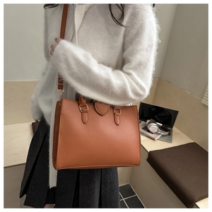 Dettaglio della borsa tote color caramello in ecopelle con trama a grana e tracolla